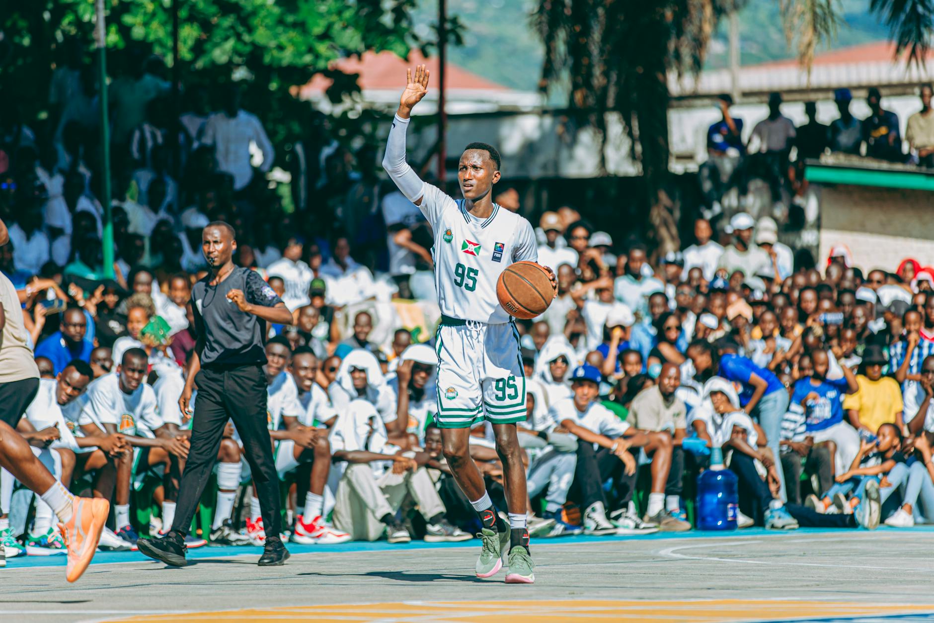Outdoor basketball game with a packed crowd watching, capturing the excitement and energy of the moment.